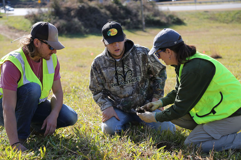 State Botanical Garden Conservation Coordinator Jennifer Ceska talks with UGA students about the native plants they’re installing off Exit 6 on the GA-10 loop. Pictured from left are Alec Dull, Andrew Oliver and Ceska. (Photo: Shannah Montgomery)