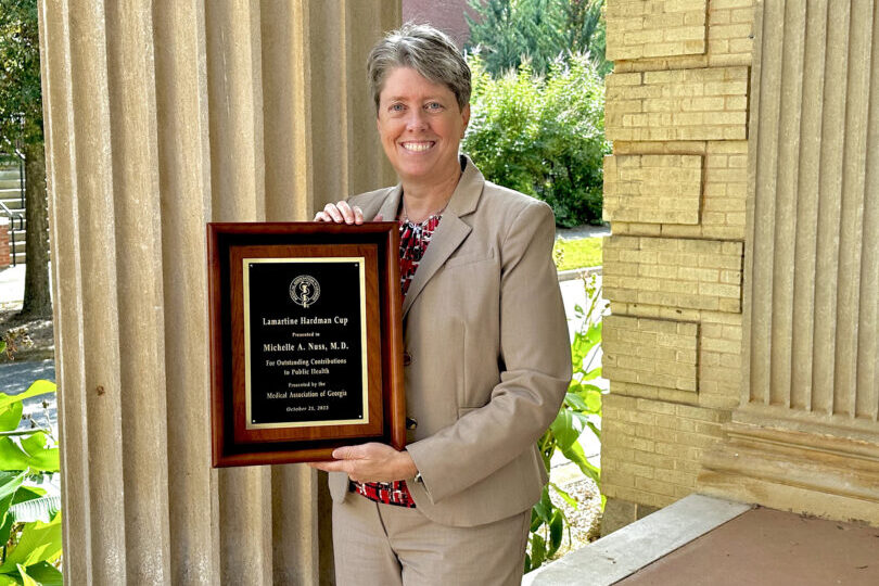 Dean Shelley Nuss holds up her new award. (Photo by Lindsey Derrick)