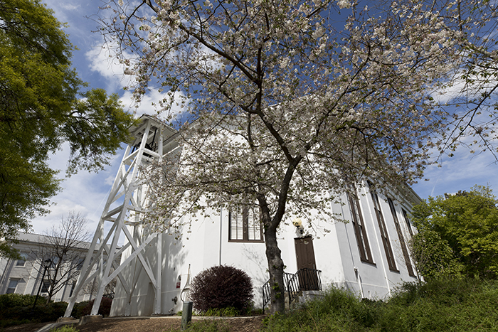 The Chapel and Chapel Bell Tower with spring trees blooming in the foreground.